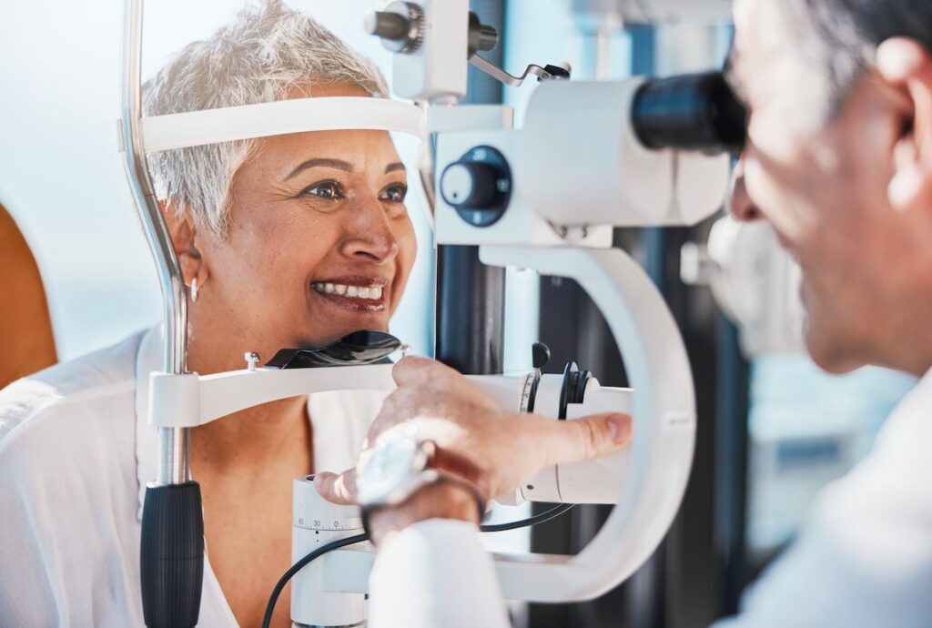 Older woman getting an eye exam with a slit-lamp machine