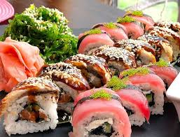 Assorted sushi rolls with sesame and toppings.